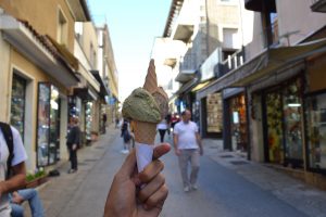 a gelato cone held forward while walking down a street